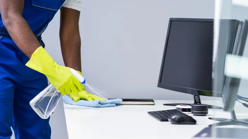 Cleaner wiping an office desk